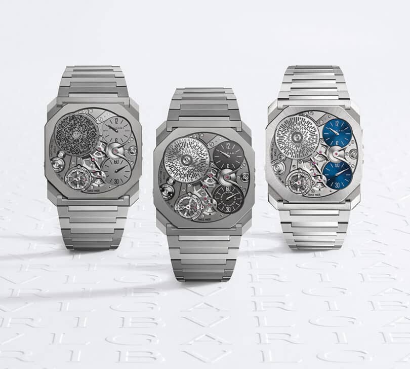 Three Bulgari Octo mechanical wristwatches with exposed gears on a branded background.