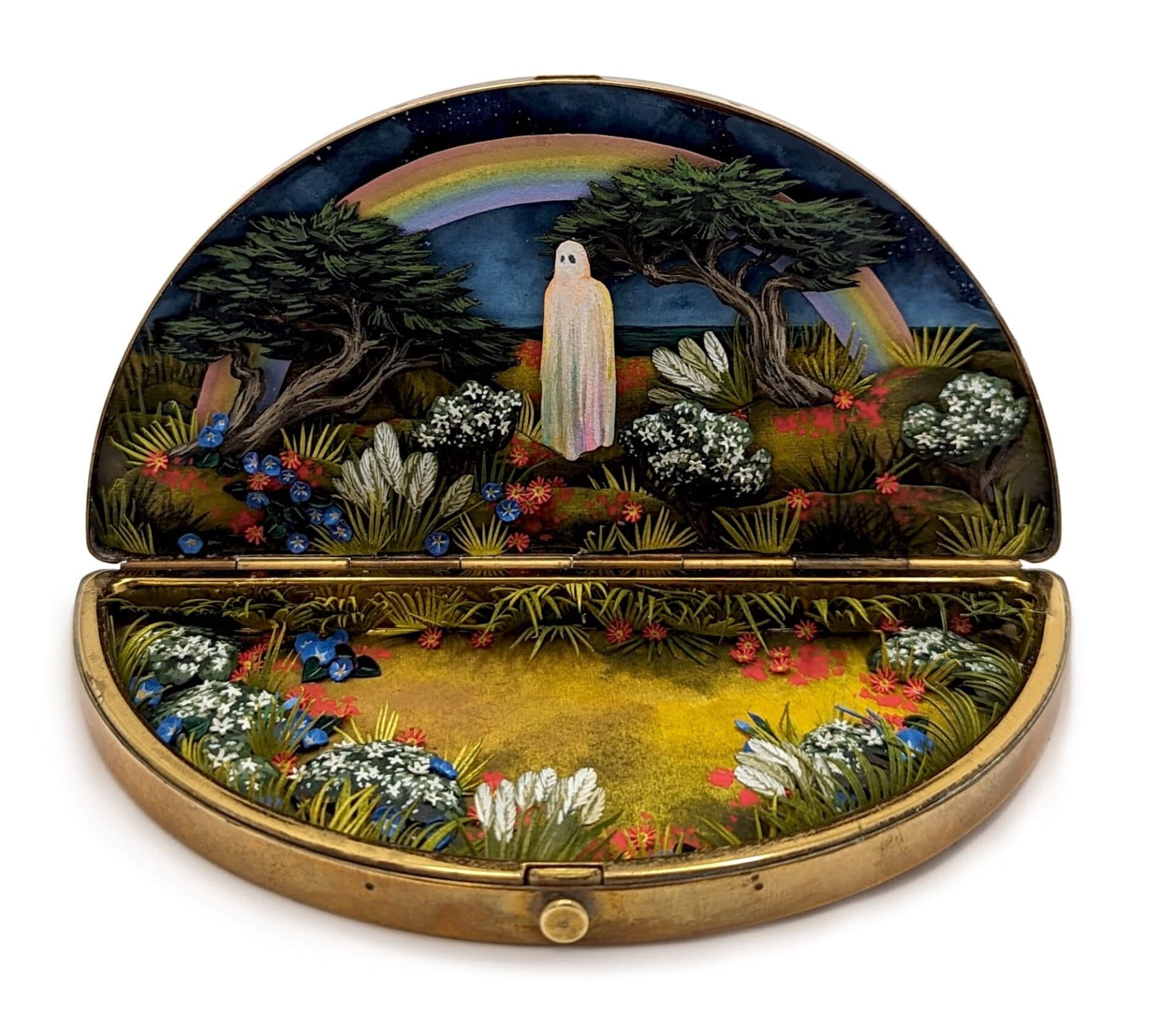 a tiny diorama made from watercolor-painted paper inside of a semi-circular vintage cosmetics compact depicting a ghost in a lush meadow with a couple of trees and a rainbow overhead