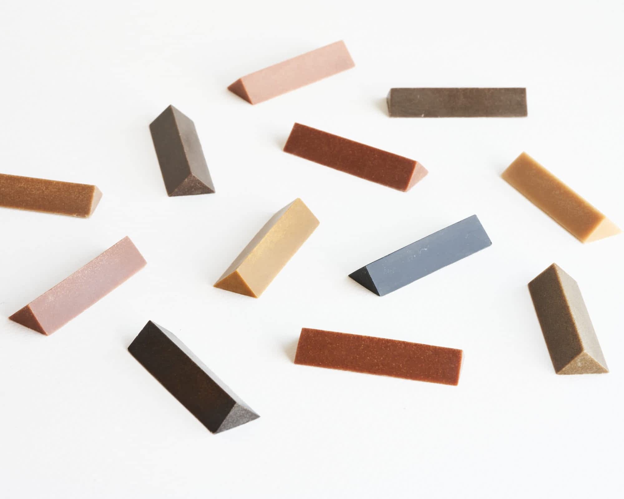 an array of colorful, triangular crayons made from the naturally occurring colors of wood from different trees