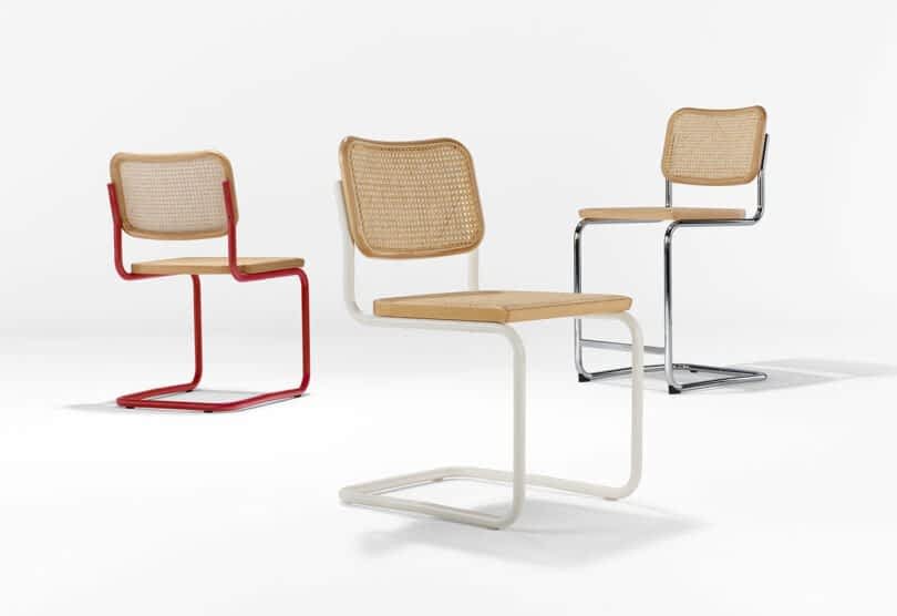Three modern cantilever chairs with light-colored woven seats and backs. Each chair has a different colored metal frame: red, black, and white, arranged on a plain white background.