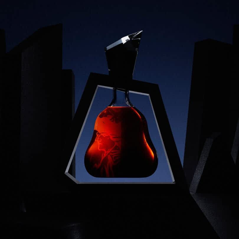 A sharply angled-shaped cognac bottle with dark liquid inside surrounded by a geometric black frame, set against a dark background.