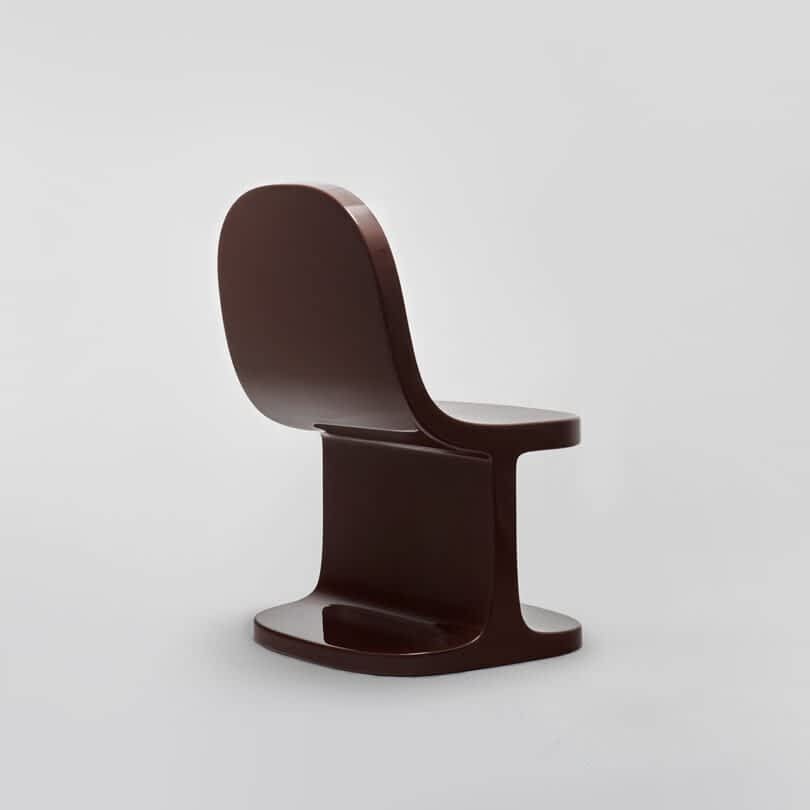 Brown modern chair against a neutral gray background.