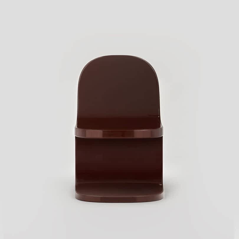Brown modern chair against a neutral gray background.