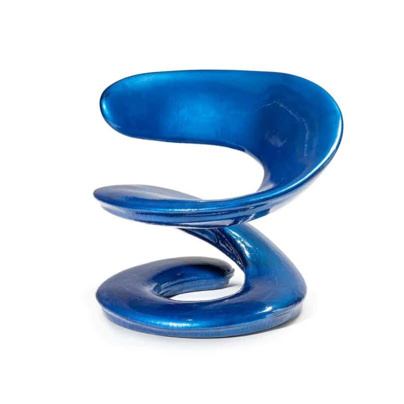 A modern, sculptural chair with a shiny blue finish featuring a continuous, fluid design with no distinct legs or backrests