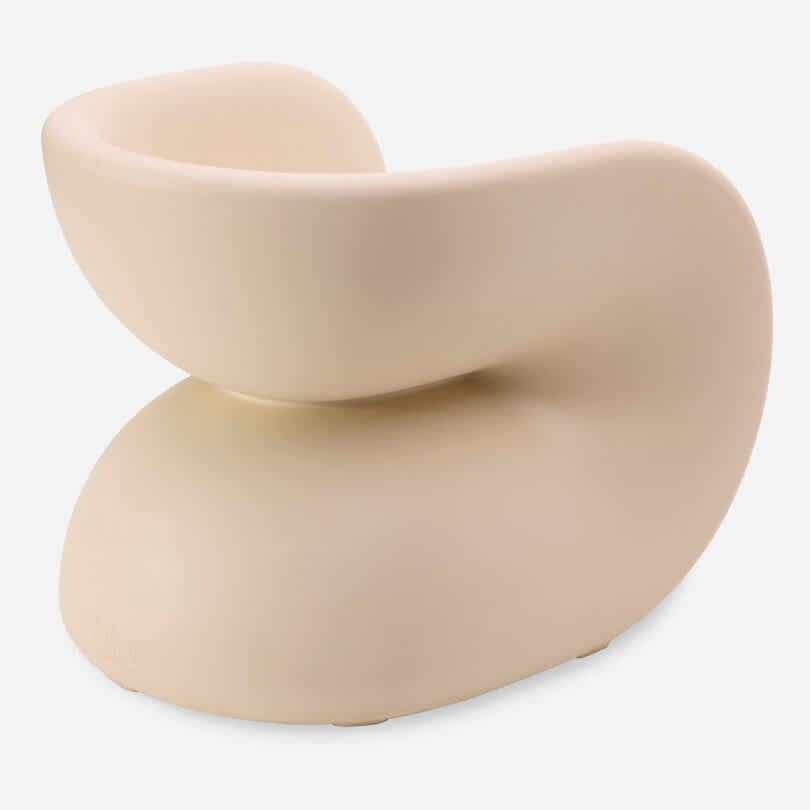 A modern cream chair with a curved, sculptural shape on a white background.