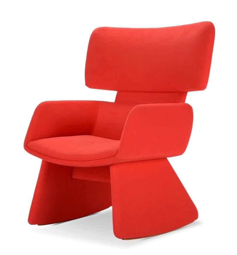 A modern red lounge chair with a wide, curved backrest and angled legs and seat.