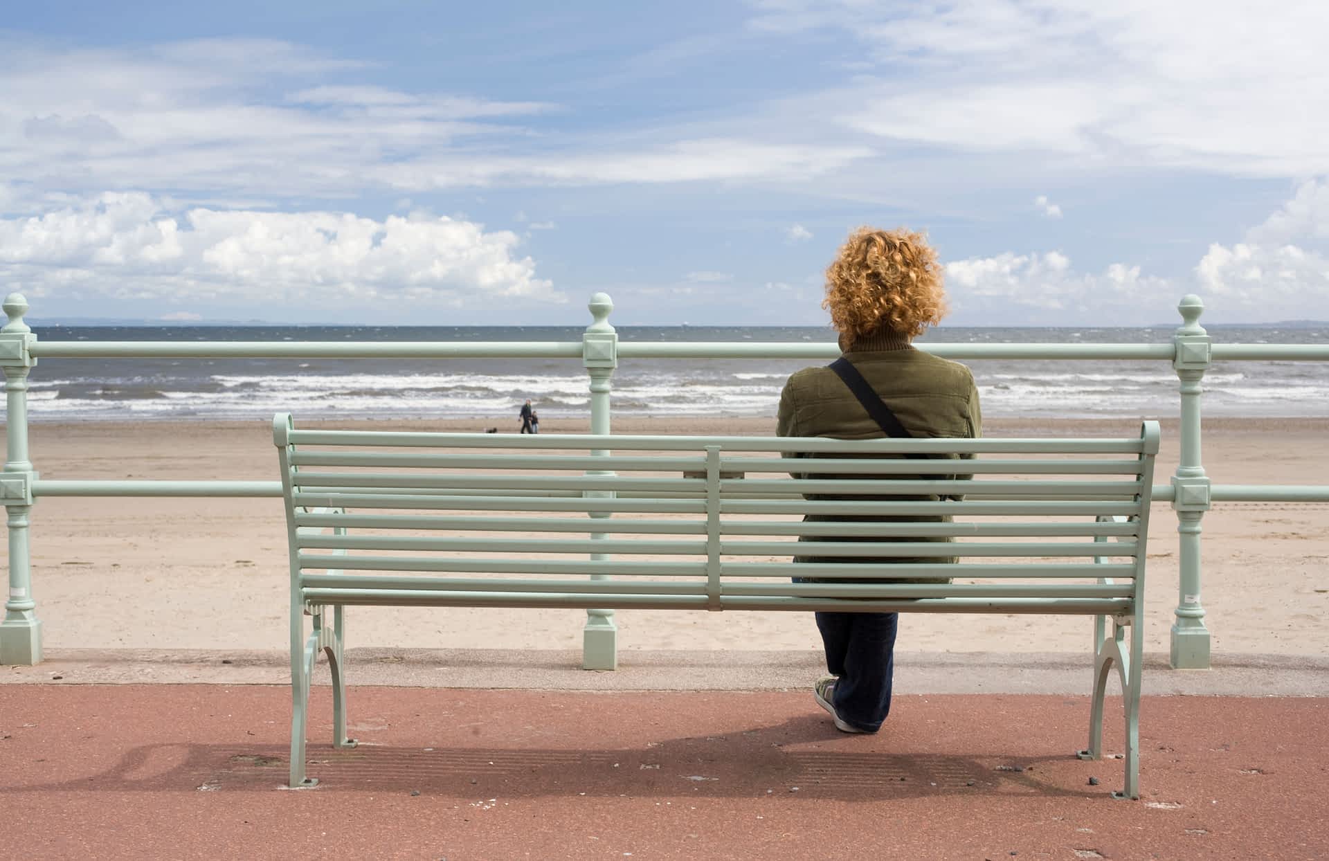 Edinburgh's beaches have a soul-soothing magic, whatever the weather. A woman sitting at a beach on the seafront near Edinburgh.