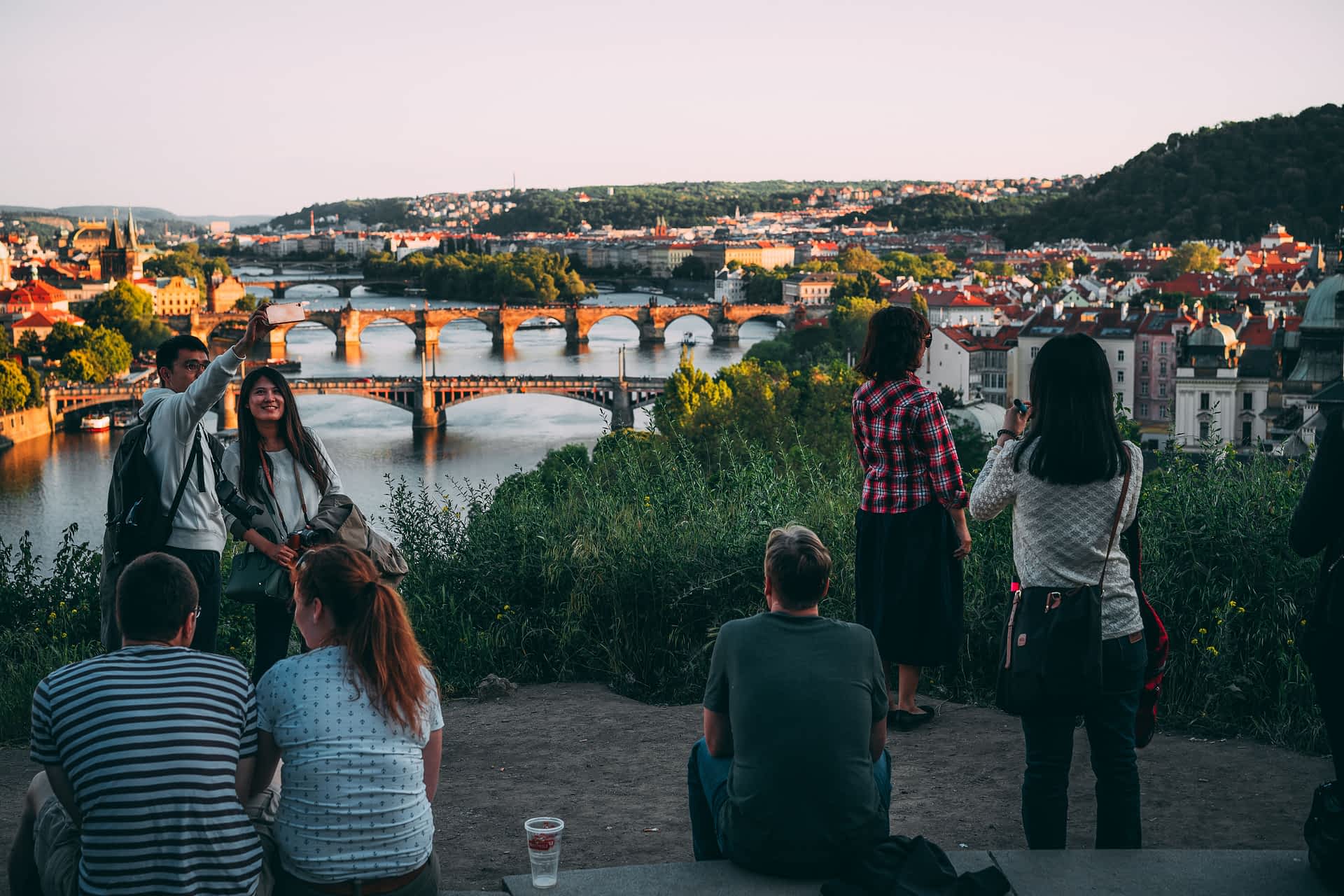 Letna Park, Prague People enjoying the sunset over a city with a river running through the center of it