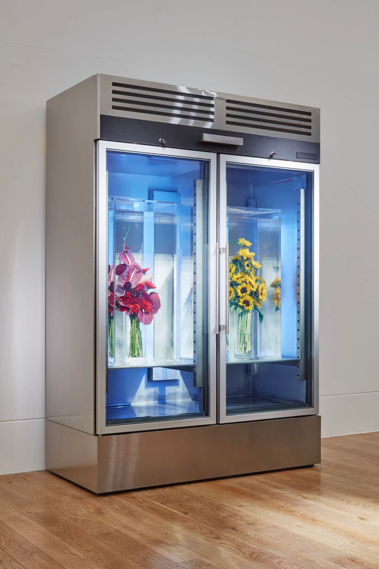 a floral cooler with two bouquets inside, each suspended inside silicone oil to preserve their freshness