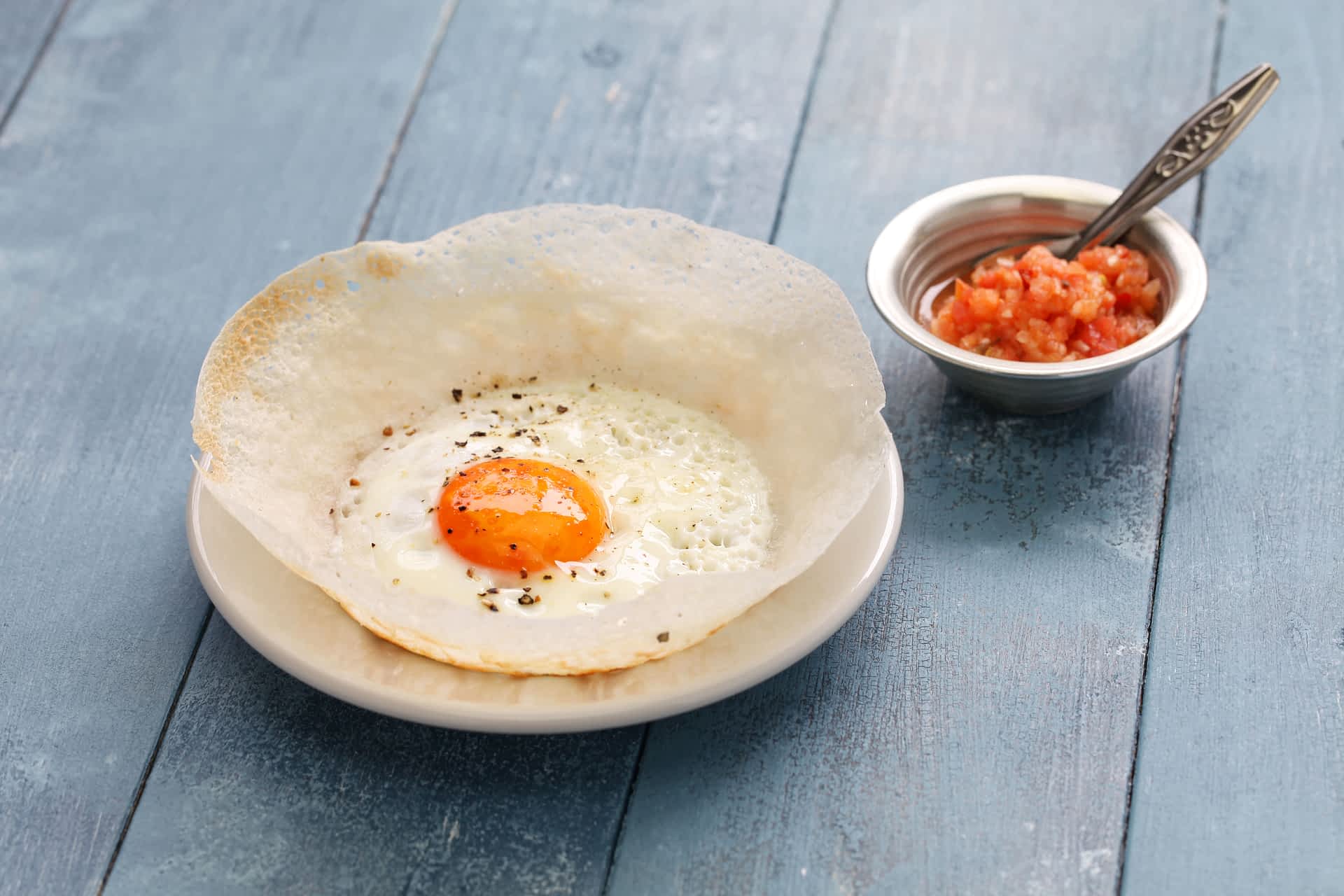GettyRF543978524.jpg Sri Lankan egg hopper (bittara aappa) served on a plate.