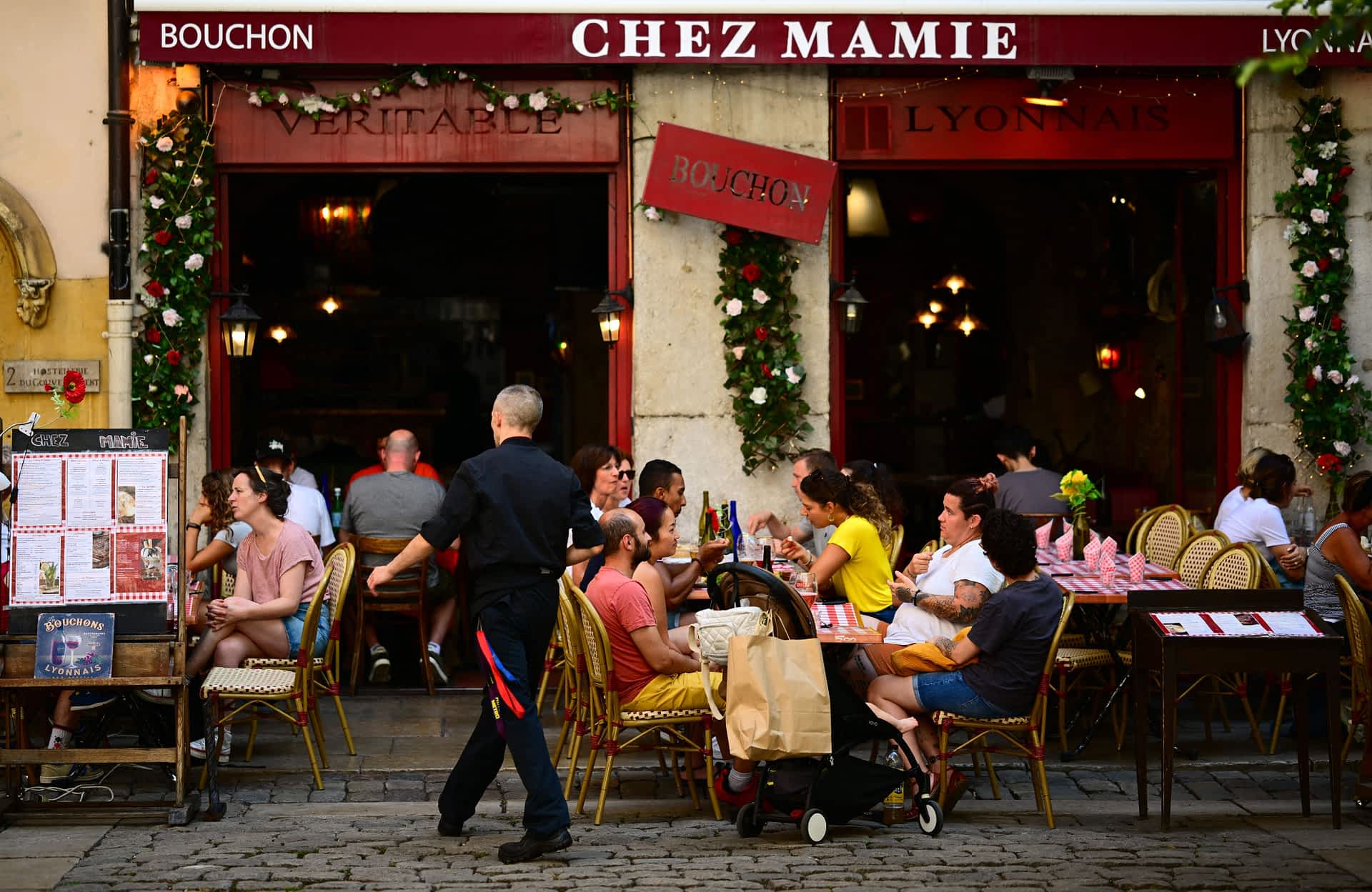 Bouchon People eat at tables outside a Bouchon, a traditional Lyon restaurant, in the old city part of Lyon.