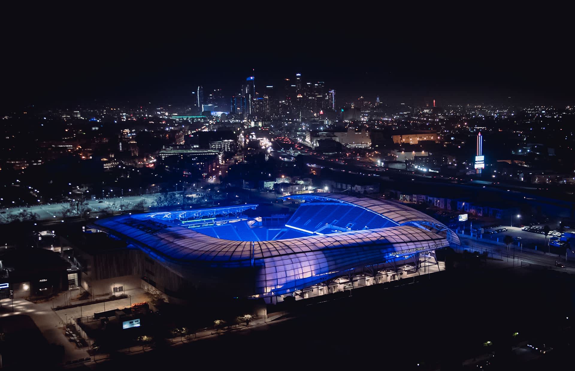 BMO Stadium by night, Los Angeles, California, USA BMO Stadium illuminated with purple lights in an aerial view with the Los Angeles skyline in the distance