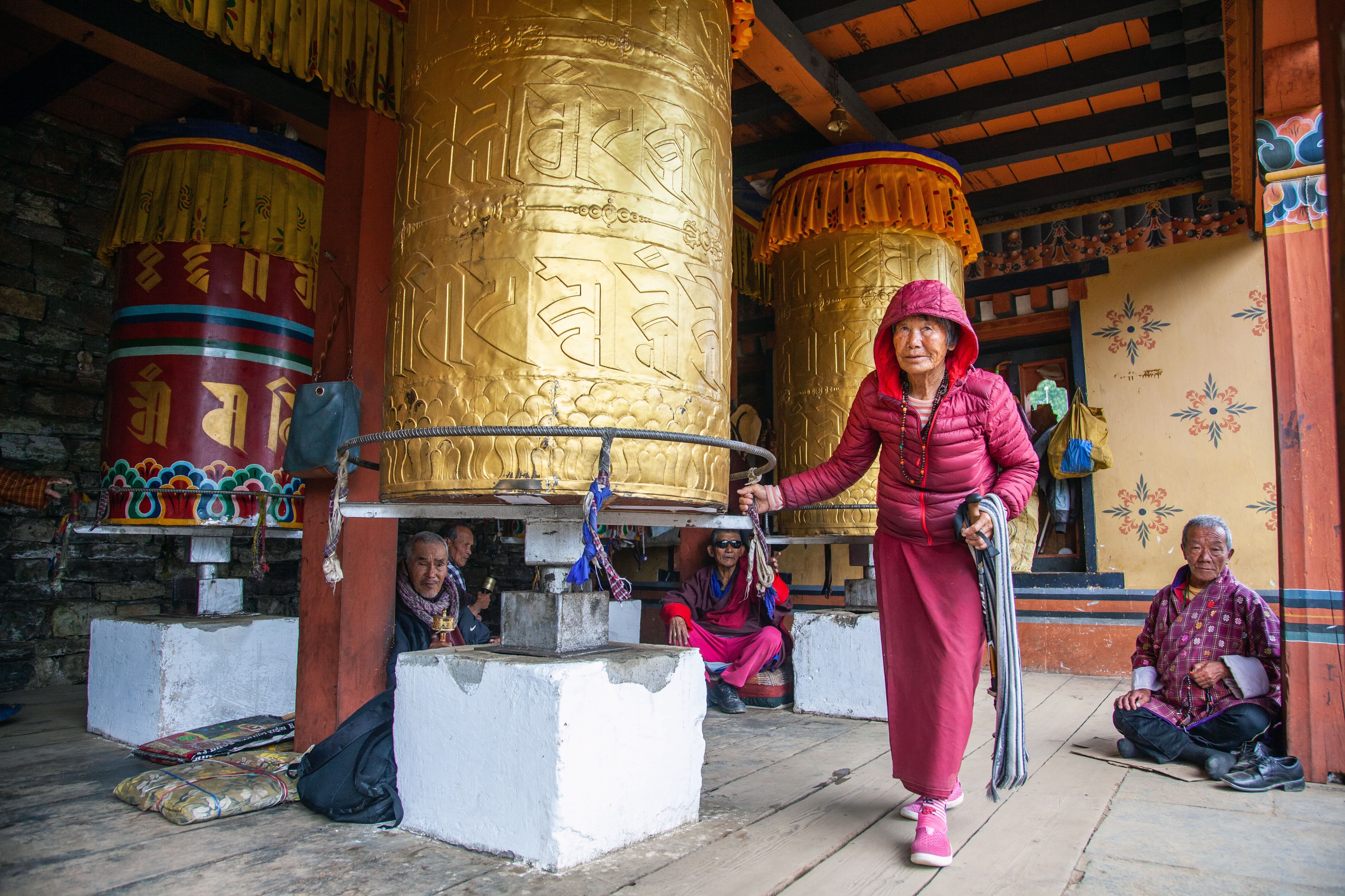 The National Memorial Chorten complex in Thimphu, Bhutan An old woman spinning a big prayer wheel at National Memorial Chorten complex in Thimphu, Bhutan
