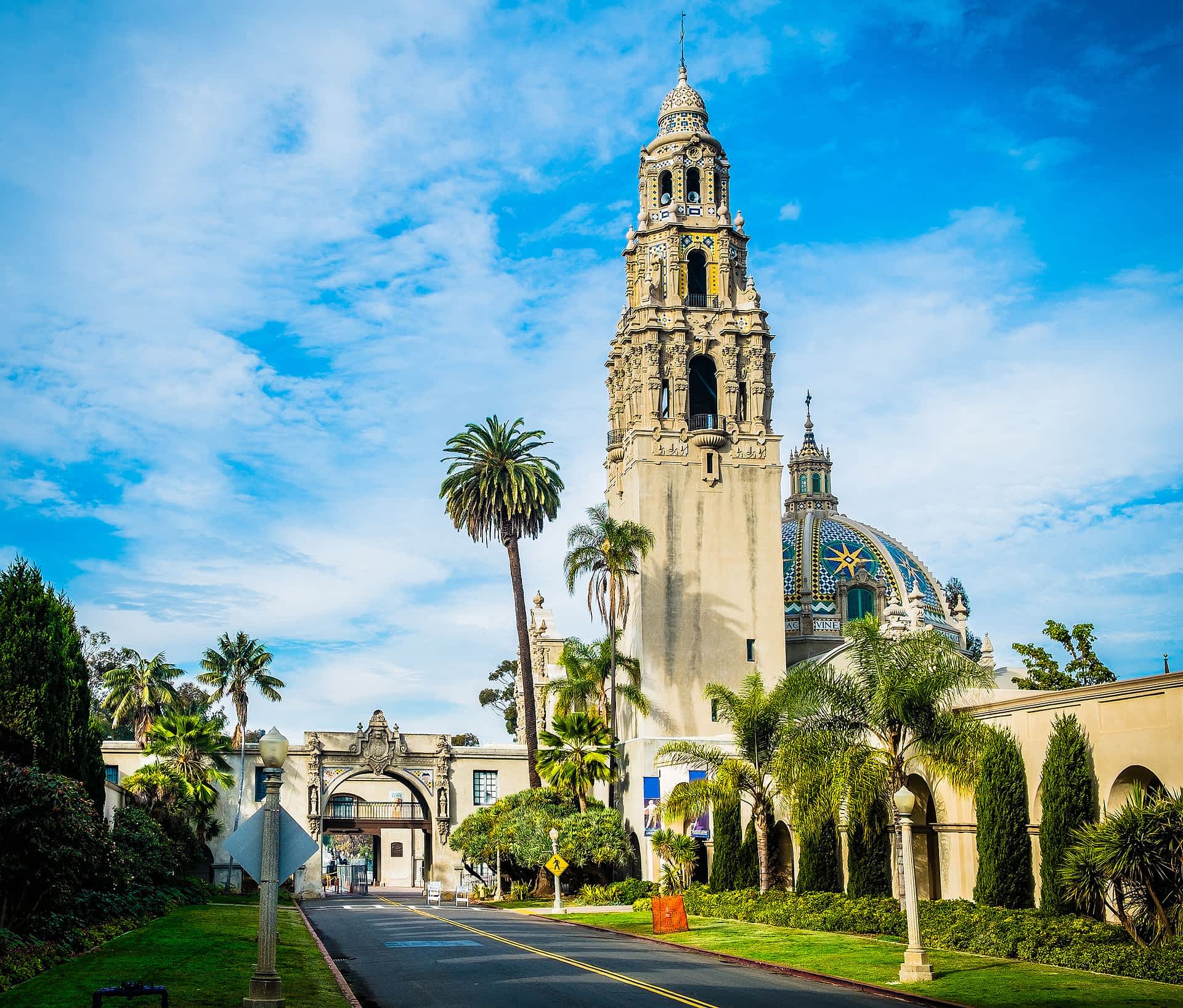 A building with a tall bell tower in landscaped parkland
