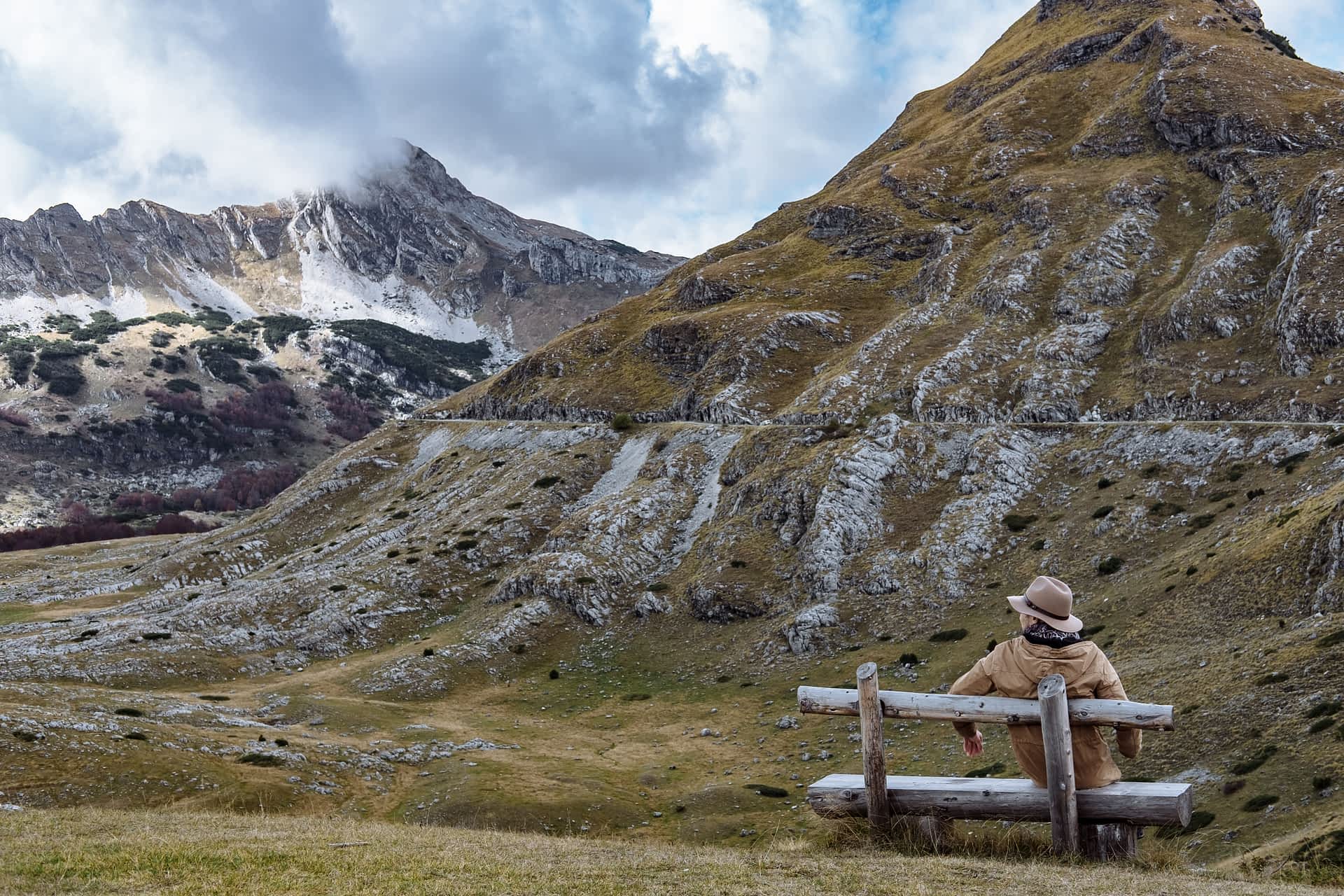 Durmitor, Montenegro A solo hiker sits on a bench enjoying autumn in the mountains of Durmitor, Montenegro