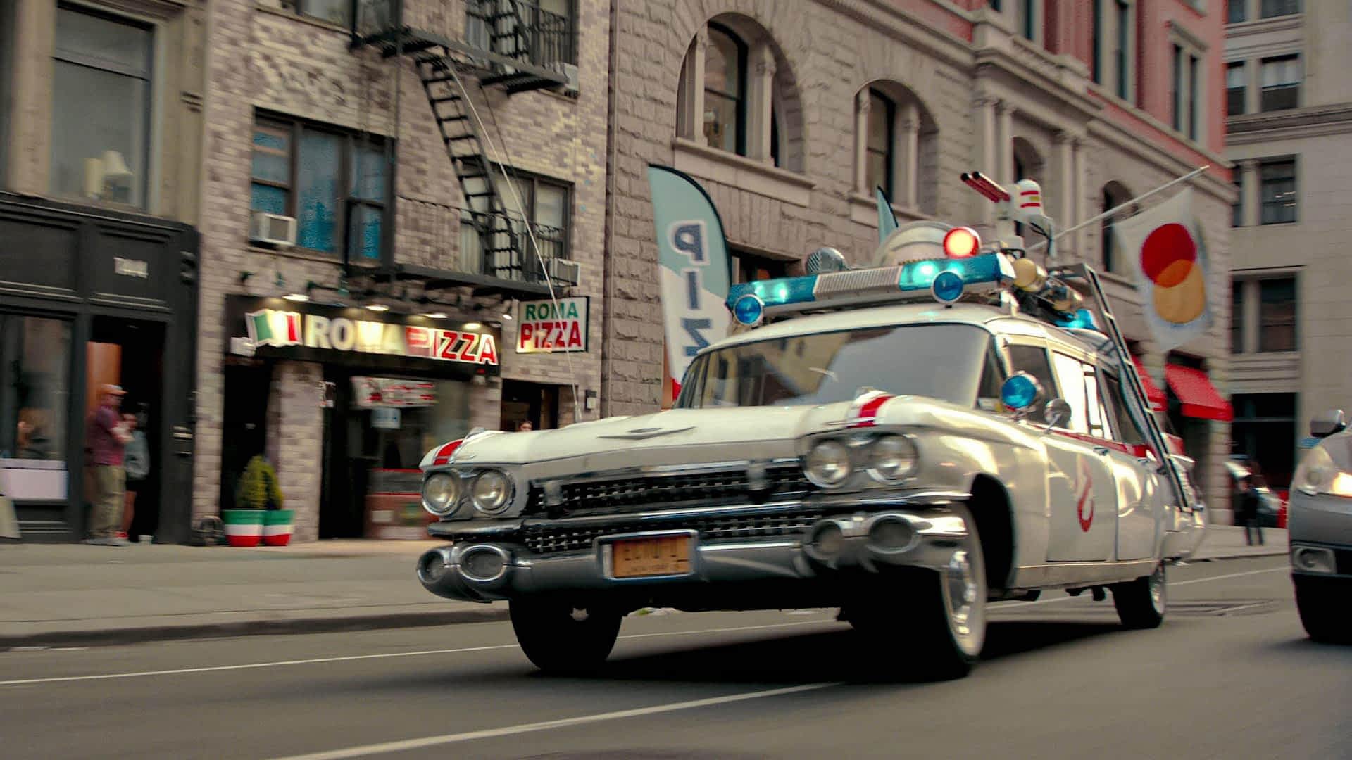 2WNTX62-RM.jpg A vehicle resembling a police car but with extra lights and guns mounted on the roof speeds through a city street
