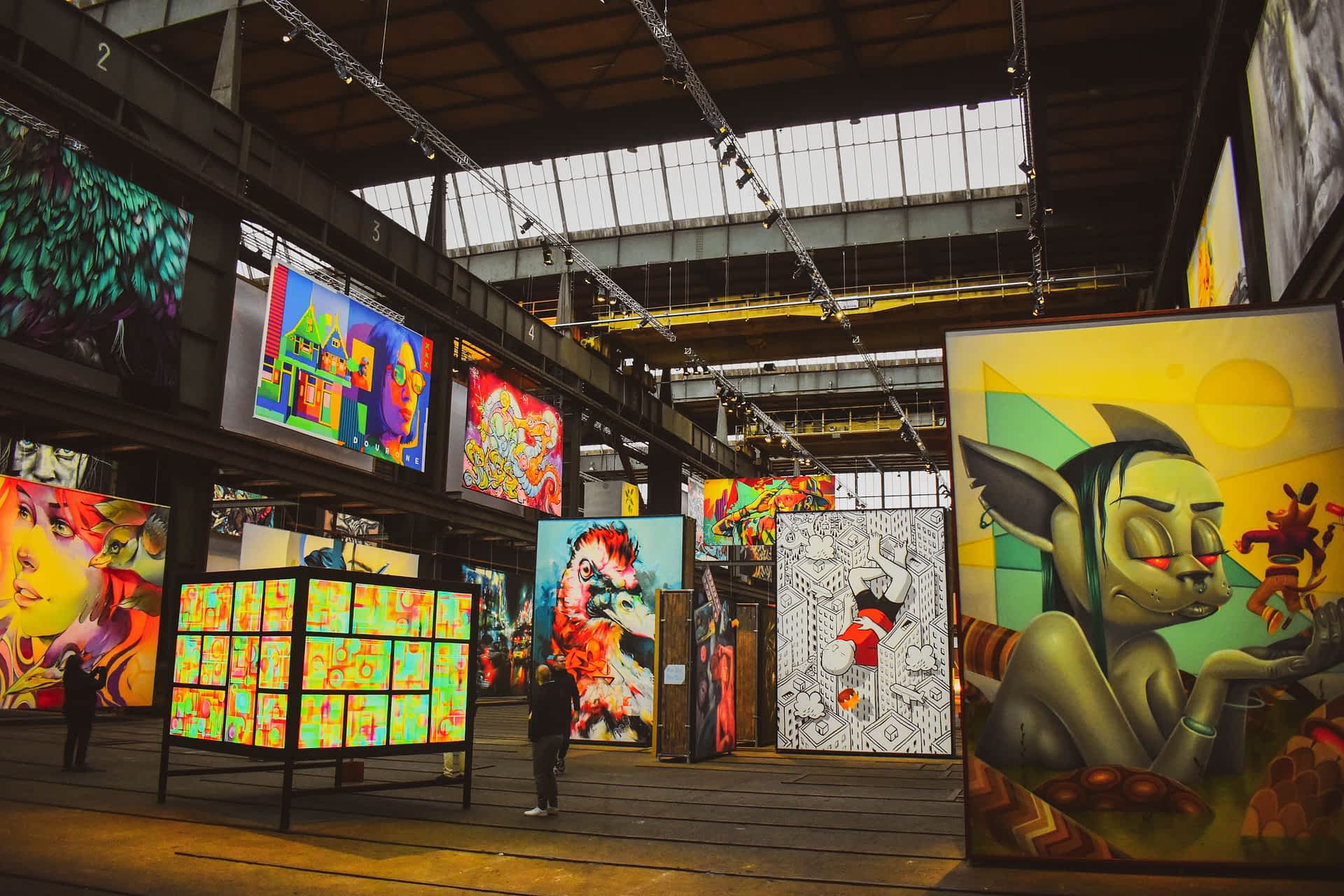 shutterstock2289096231.jpg People gaze at vast displays of street art and graffiti in a warehouse-like gallery space