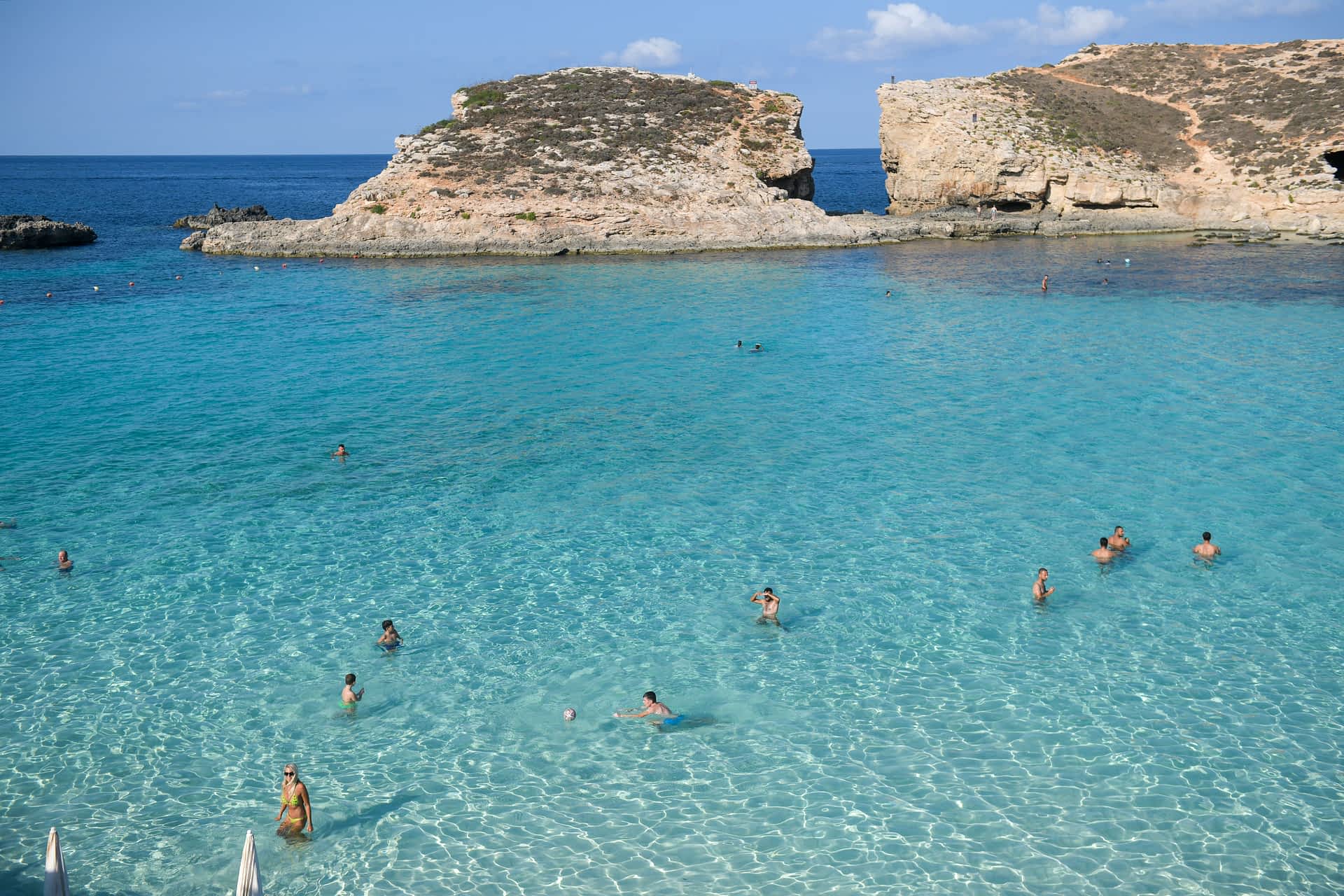 Malta-Comino-Blue-Lagoon People swim in the bright blue waters of Malta's Blue Lagoon.