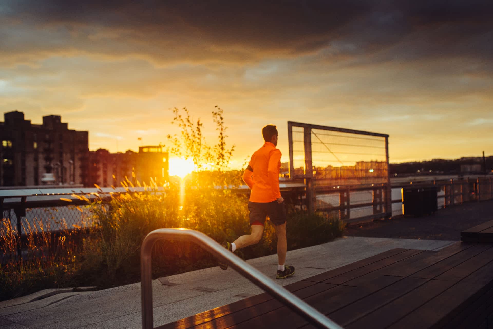 High-Line-New-York-City.jpg A man in a flourescent orange jacket is running along the New York High Line at sunset.