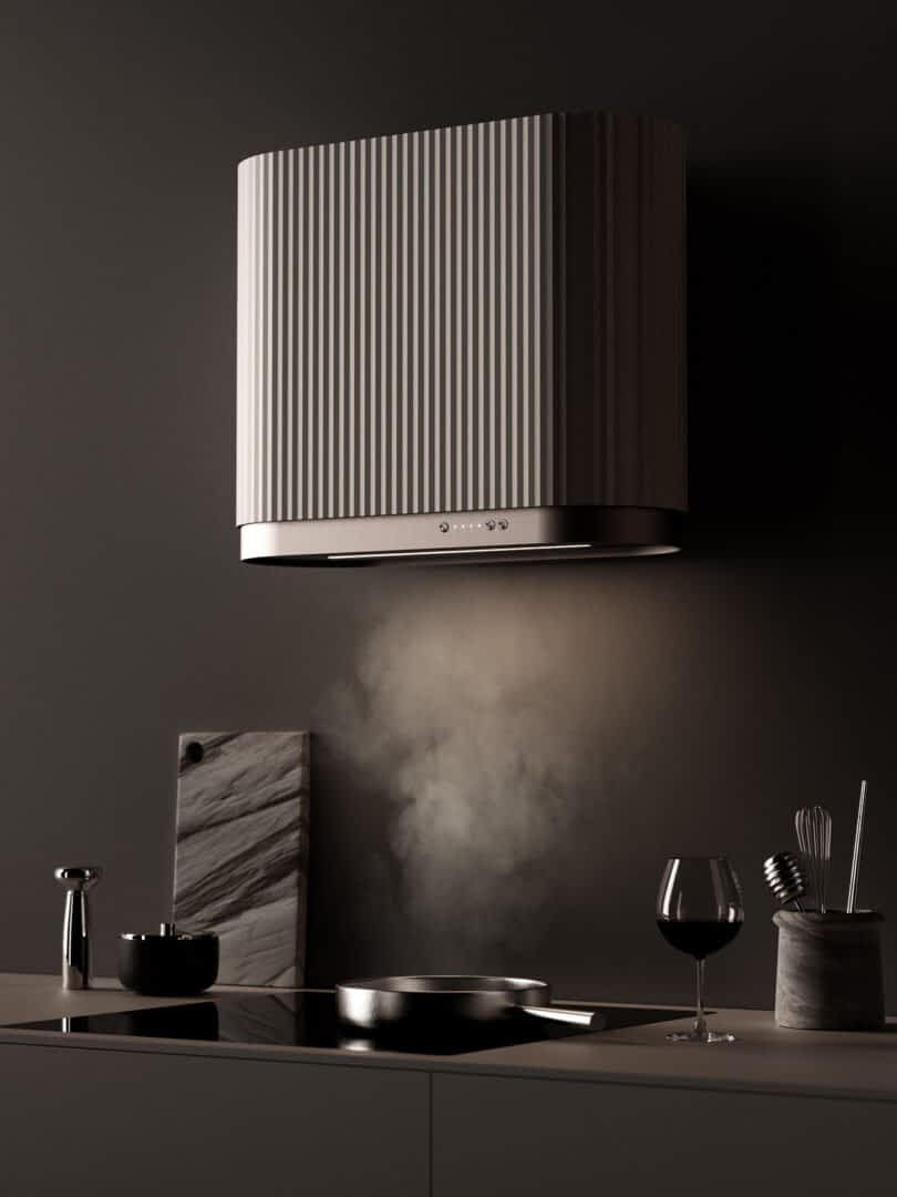 Modern kitchen with an island featuring a steel cooktop under a Ciarko Design Mono kitchen hood, emitting steam, alongside a wine glass, utensils, and cutting board.