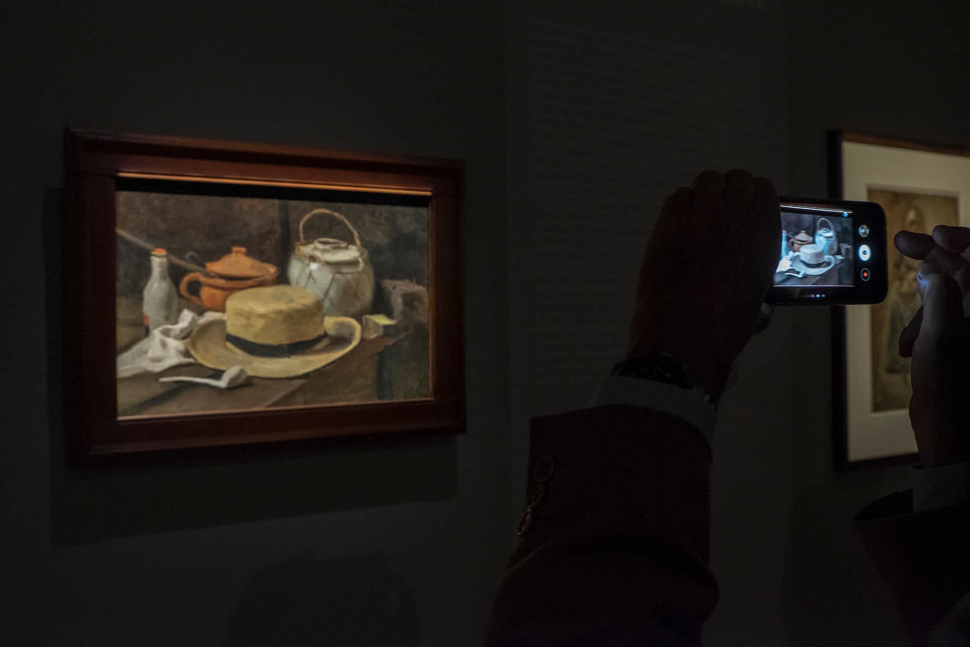 Press Preview of Van Gogh Exhibition In Verona A visitors takes a photo of Van Gogh's painting Still Life with Yellow Straw Hat which hangs in the Kroller-Muller Museum in the Netherlands