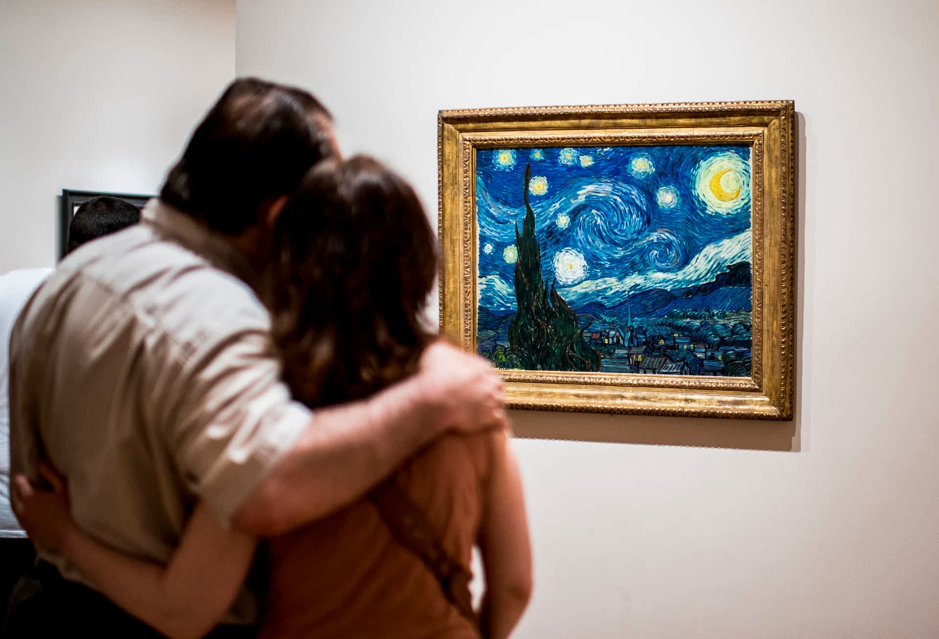 Features of New York - New York City - USA Two tourists, one with their arm around the other, look at The Starry Night by painter Van Gogh at Museum of Modern Art (MoMA), New York.