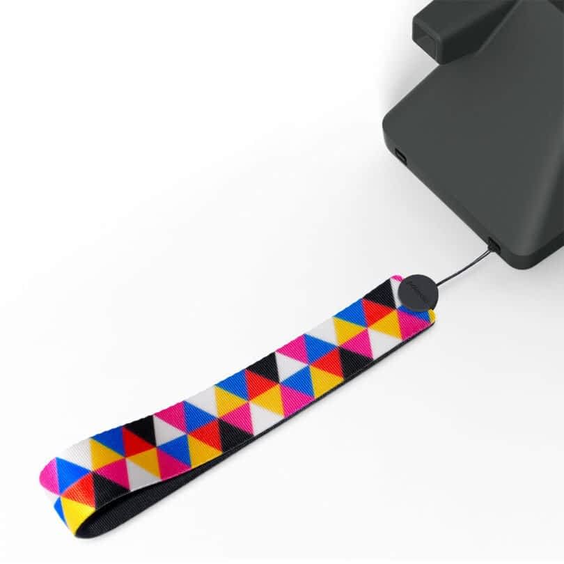 A close-up image of a black device with a multicolored, triangular-patterned lanyard attached to it.