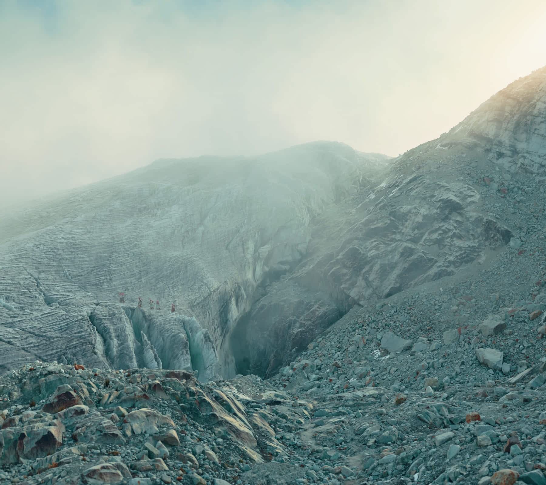 five women, photographed in the distance, climb an atmospheric mountain