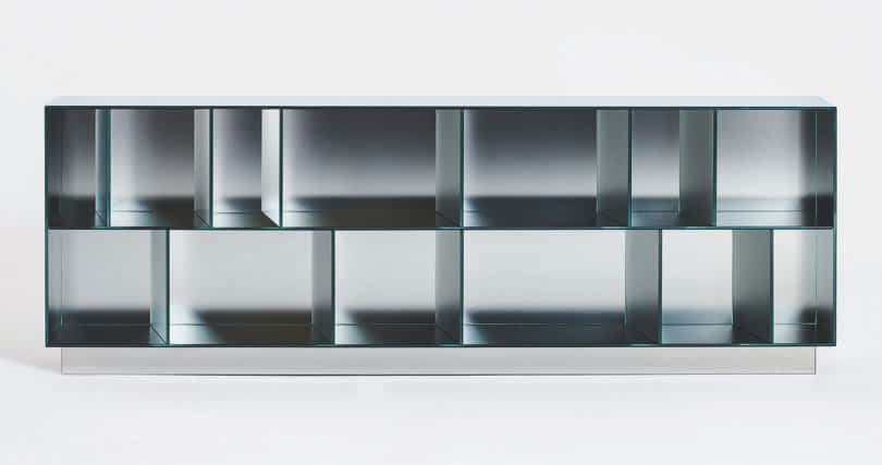 Modern metal storage unit with a geometric design featuring multiple square and rectangular compartments, positioned against a plain white background.