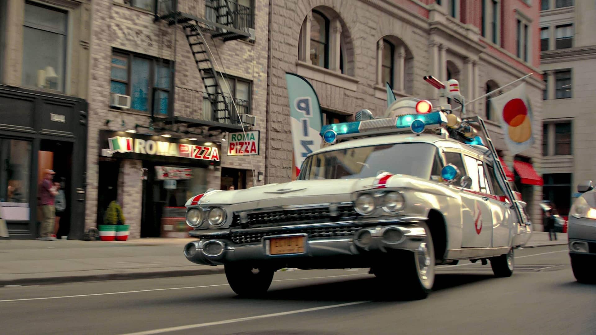 2WNTX62-RM.jpg A vehicle resembling a police car but with extra lights and guns mounted on the roof speeds through a city street