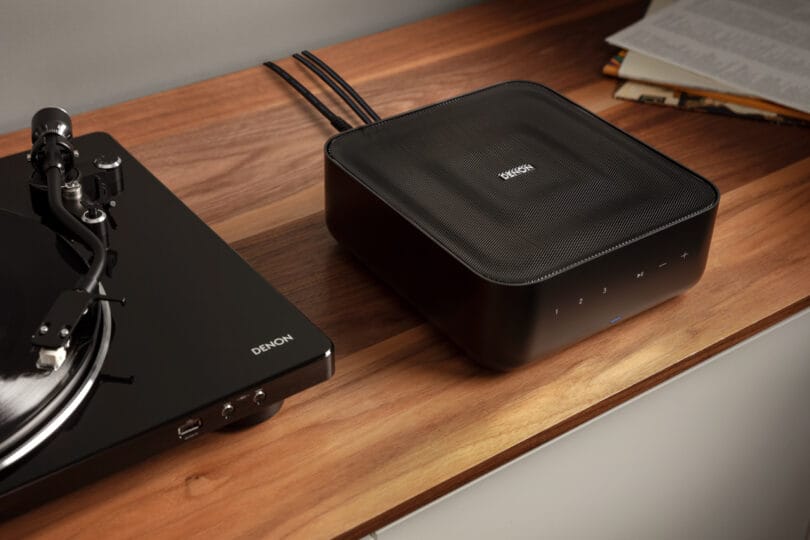 A Denon turntable connected to a Denon Home Amp on a wooden surface, displaying both analogue and digital audio equipment.
