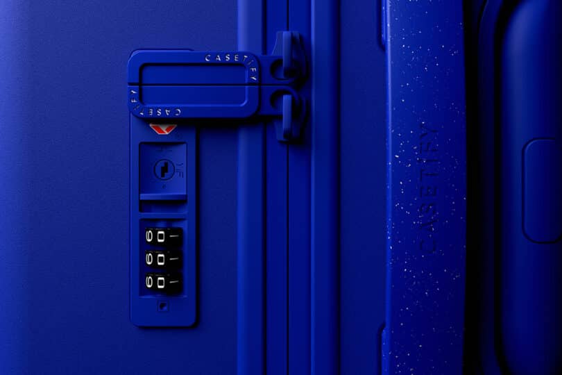 Close-up of a blue suitcase lock with a combination dial and handle. The brand name Casetify is embossed on the side.