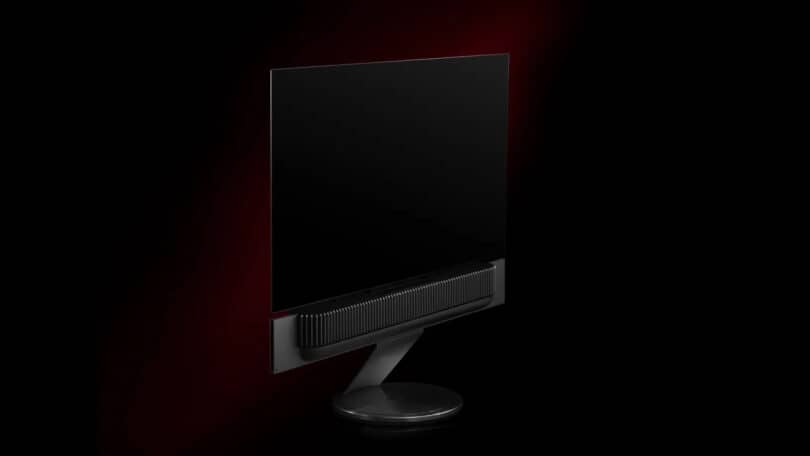 A sleek, black flat-screen monitor with a minimalist design against a dark red background.