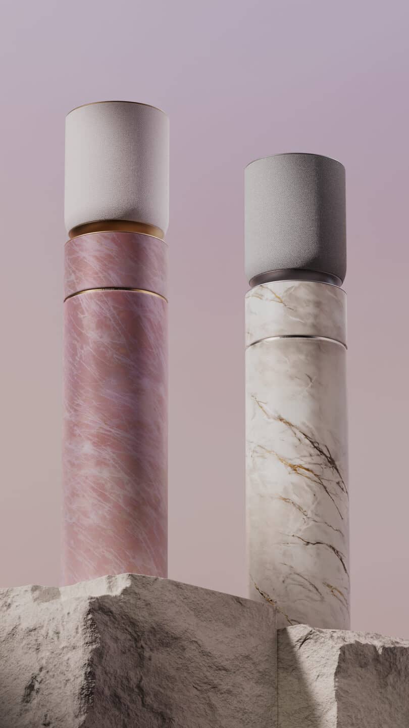 Two cylindrical objects with marble textures, one pink and one white, stand vertically on a rocky surface against a gradient sky background.