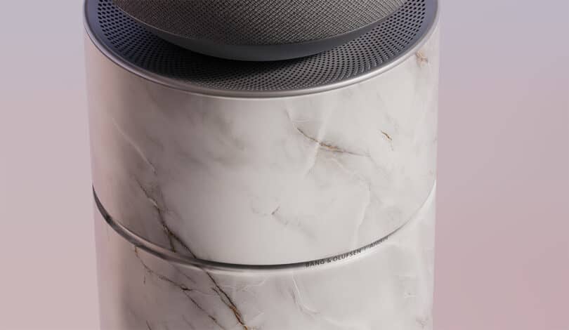 Close-up of a modern speaker with a marble-textured cylindrical base and a mesh-covered top speaker grille.