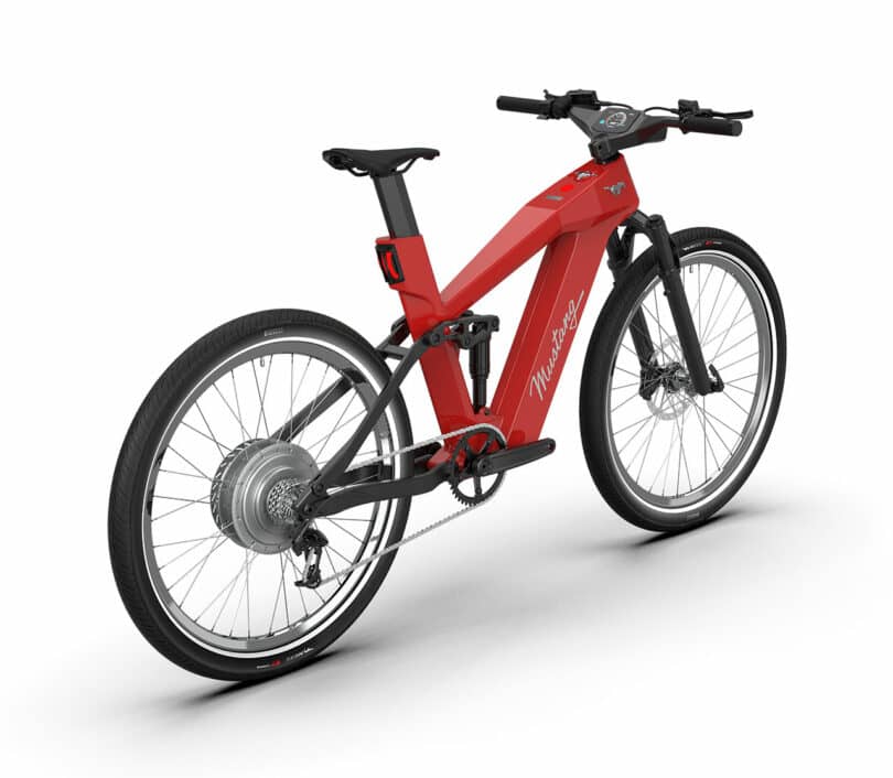 The Mustang-red electric bicycle boasts a sleek design, featuring thick tires, a digital display, and a rear motor hub, all viewed from an angled perspective.