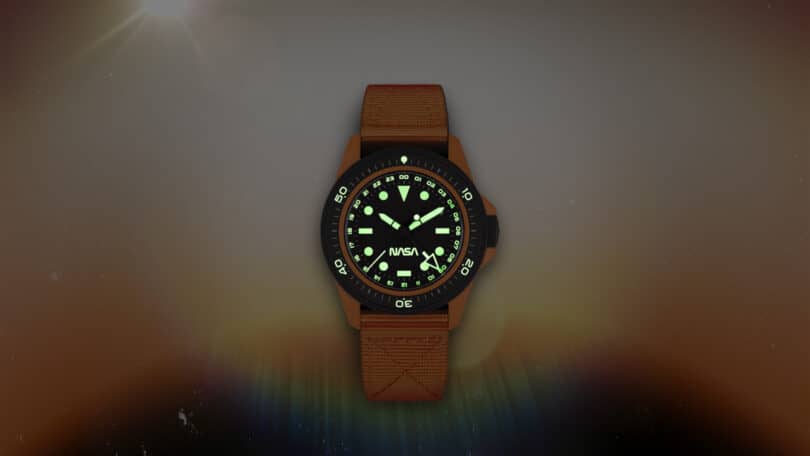 A wristwatch with a brown strap and a glowing analog face displaying the time. The watch face has visible hour markings and a logo near the center. It is set against a gradient background.